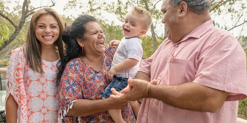 Three generations of a family together, smiling.